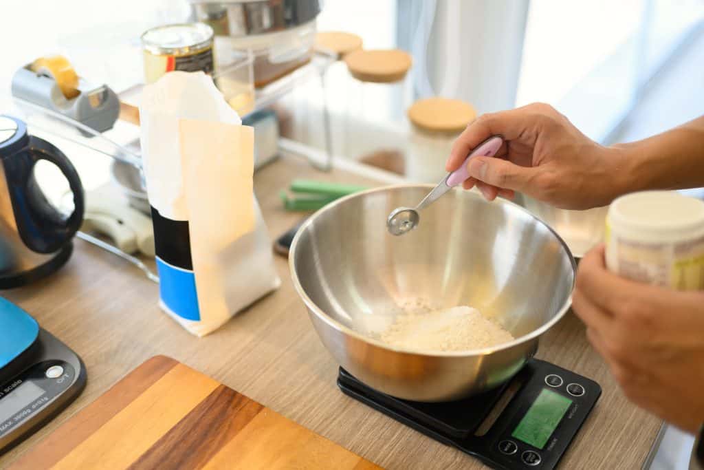 Cuánto cuesta realmente una ración de salsa: cómo calcular el coste en tu cocina 2 Pesando salsas en un recipiente en cocina